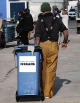 fisherman holding upcycling the oceans trash container