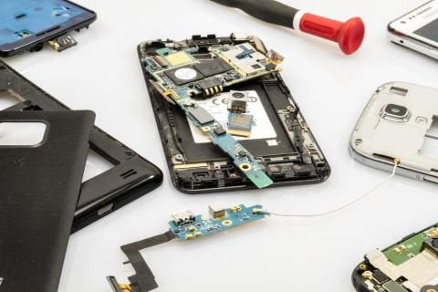 Several disassembled smartphones and their internal components spread out on a surface.