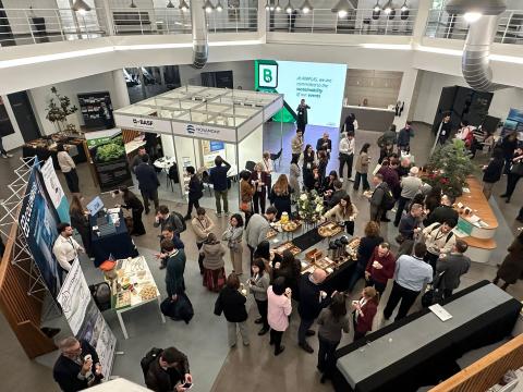 Photo of people standing and talking in an open area with posters