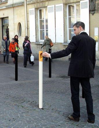 Man stubbing ut a cigarette in a street ashtray