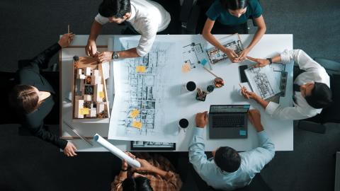 People designing a building, with papers and models