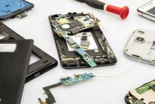 Several disassembled smartphones and their internal components spread out on a surface.
