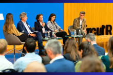 5 people on a stage for a discussion, with the word Circul'R on the wall and an audience.