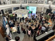 Photo of people standing and talking in an open area with posters