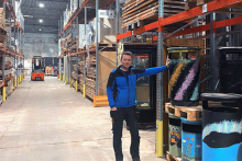 Man standing in an aisle of a warehouse filed with equipment