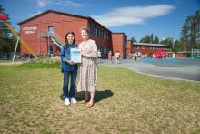 Two people standing on grass in front of a building