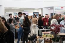 People wandering round and talking, various banners visible at stands