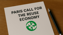 A paper on a desk, with the following words written on it: Sign the Paris Call for the Reuse Economy, and a green circular logo beneath them. There is a pen on the desk beside the paper. 