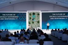 Photo of people sitting and looking at speaker, with the logo "The future of socially sustainable and responsible IT'
