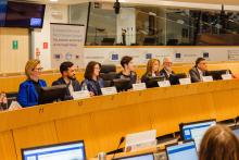 7 people with nameplates sitting in a meeting, with the banner of the ECESP annual conference behind them
