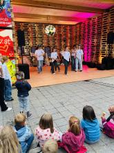 People on a stage made of pallets, with children sitting in front